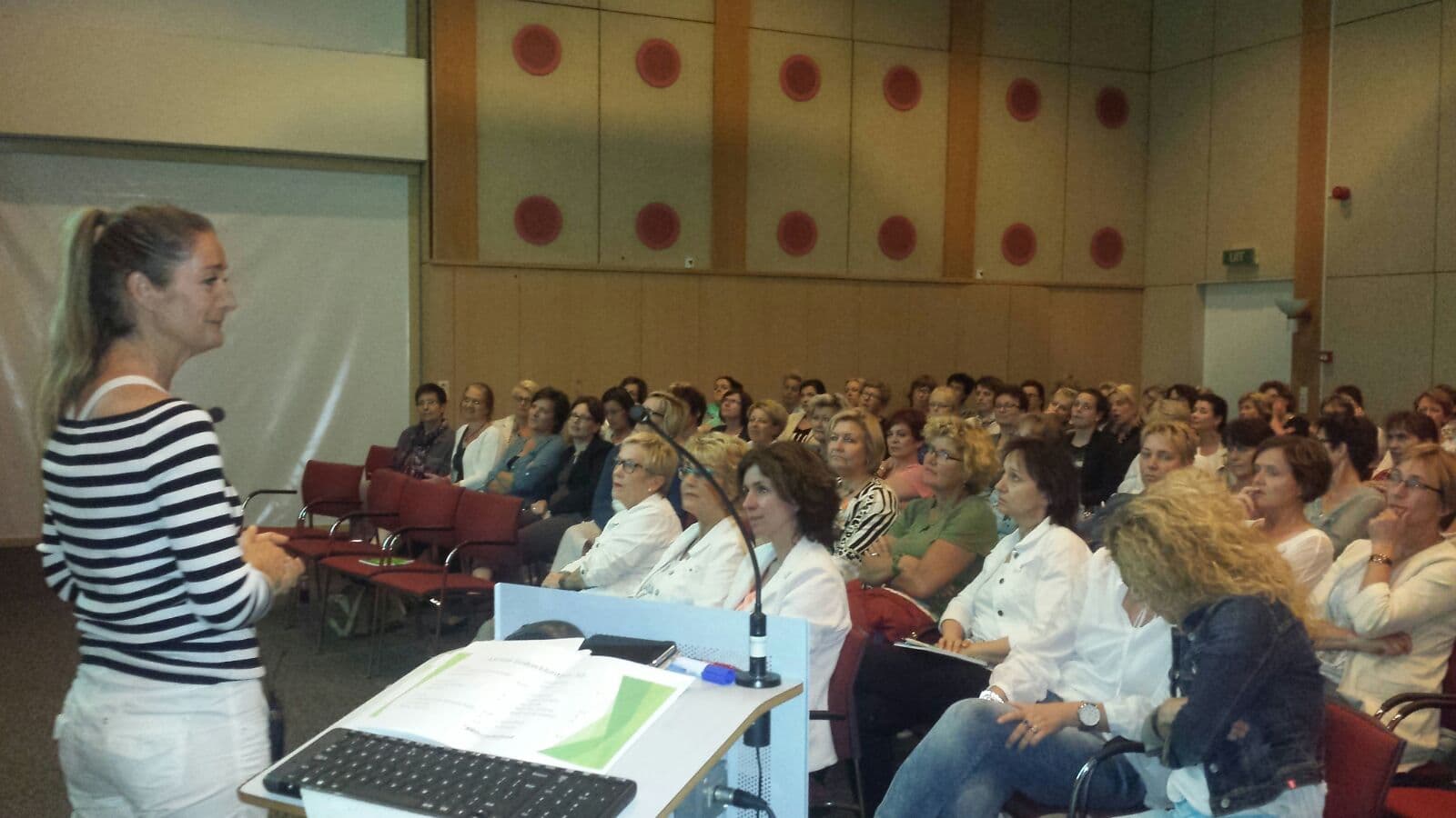 Angelien geeft een lezing voor een volle zaal